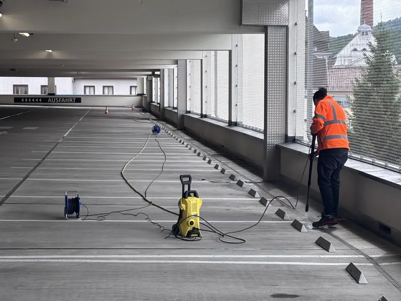 Mitarbeiter reinigt ein Parkdeck mit dem Hochdruckreiniger