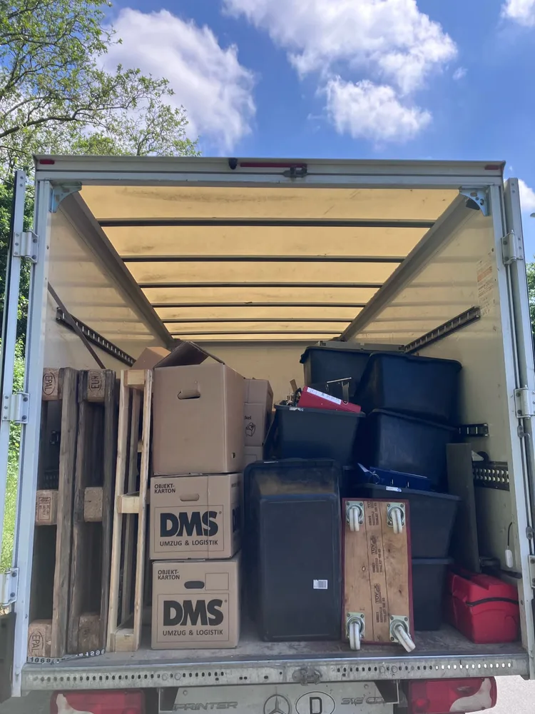 Mit Umzugskartons und Kisten beladener Transporter bei einem Büroumzug